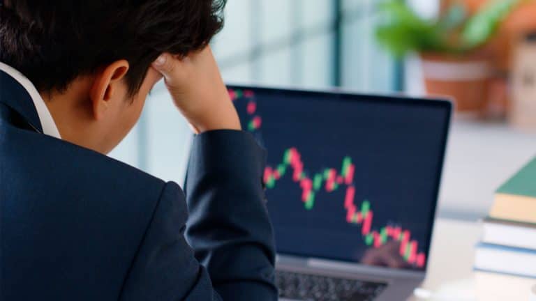 Investidor de Bitcoin acompanhando preço em queda.