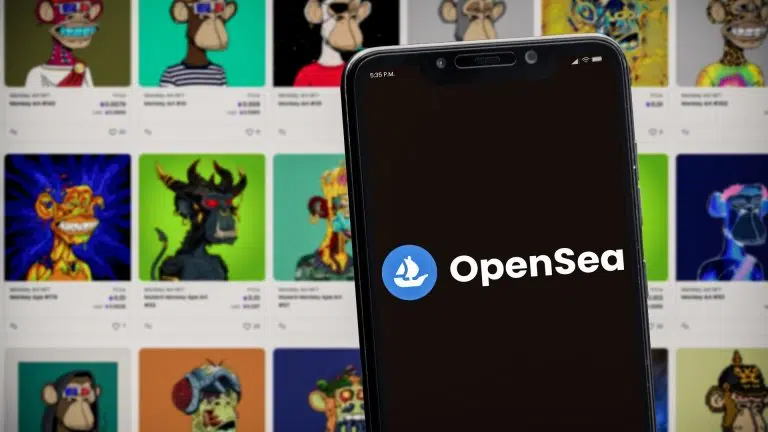 Celular com logotipo da OpenSea sobre catalogo de NFTs.