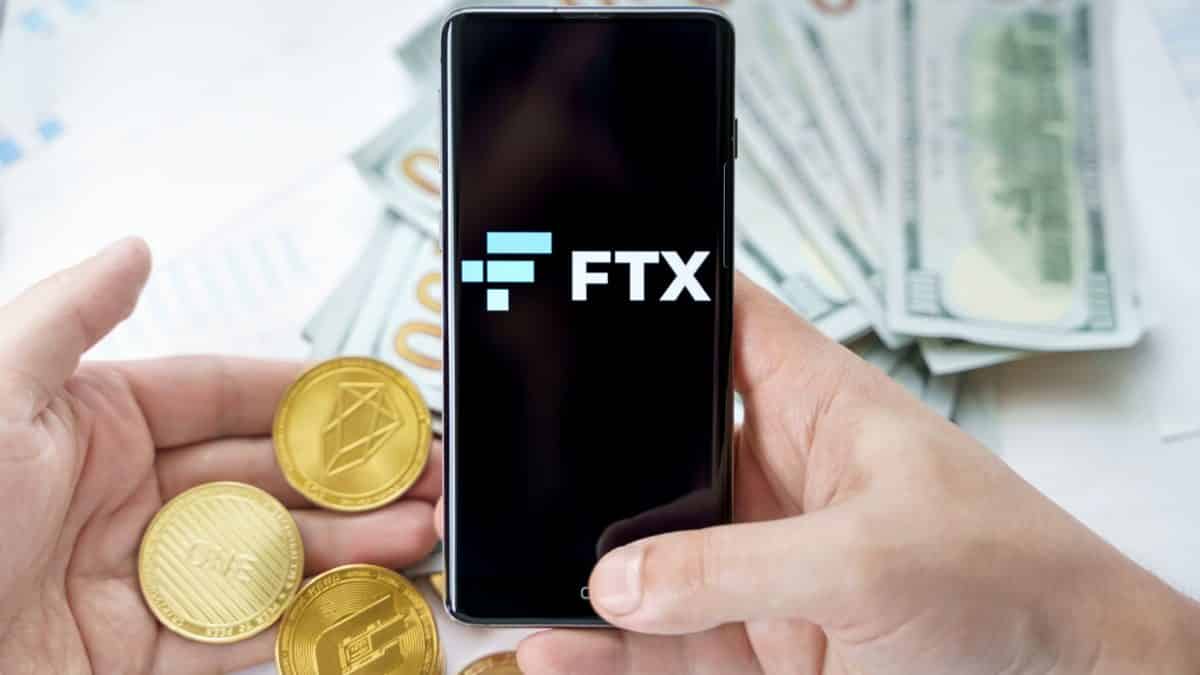 Aplicativo da FTX próximo de criptomoedas e notas de dinheiro e bitcoin