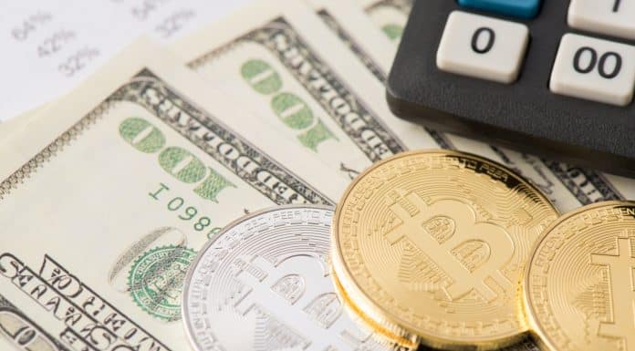 Calculadora de imposto próxima de notas de dólares e bitcoins