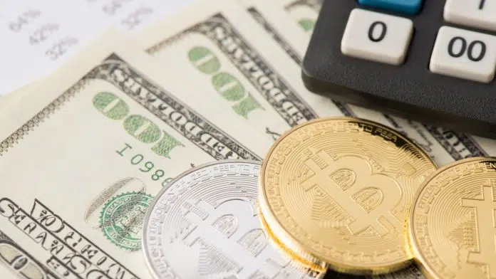 Calculadora de imposto próxima de notas de dólares e bitcoins