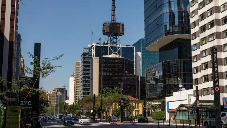 Edifício Itaú Cultural com sua icônica torre de comunicação no topo cercada por diversos prédios comerciais e complexos de escritórios na Avenida Paulista, em São Paulo