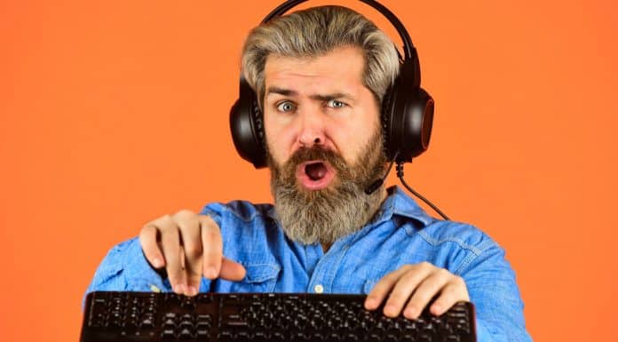 Homem escutando música desesperado no computador, criptomoedas e hackers