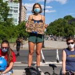Jovem manifestante segurando placa para abolir prisões