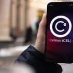 Mão segurando celular com imagem de criptomoeda de corretora Celsius