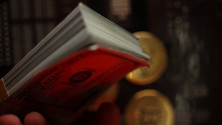 Notas de Dólar em vermelho com criptomoedas caindo ao fundo stablecoin queda caiu cai