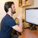 Trader de Bitcoin torcendo por sucesso de negociação com gráficos em queda