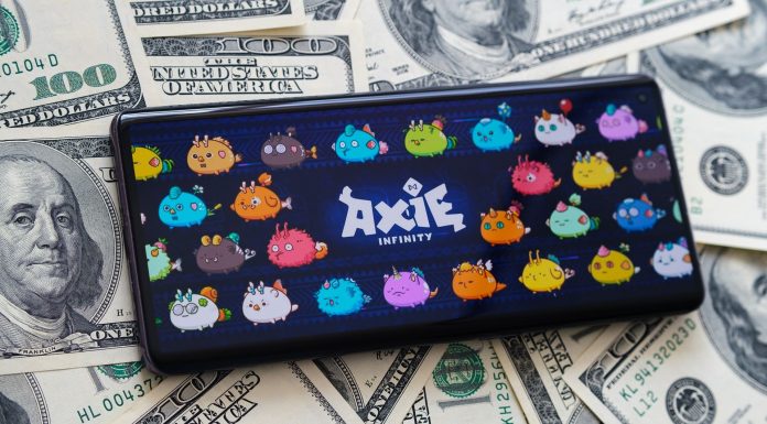 Axie Infinity em smartphone sobre notas de dólar.