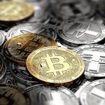 Moedas físicas de Bitcoin e da stablecoin Tether.