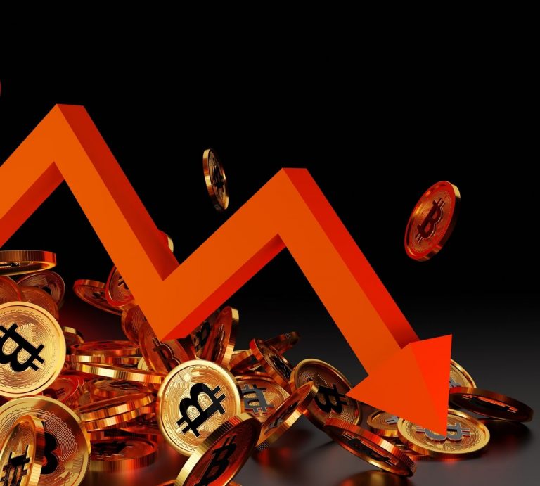 Diversas moedas de Bitcoin e seta apontando queda.