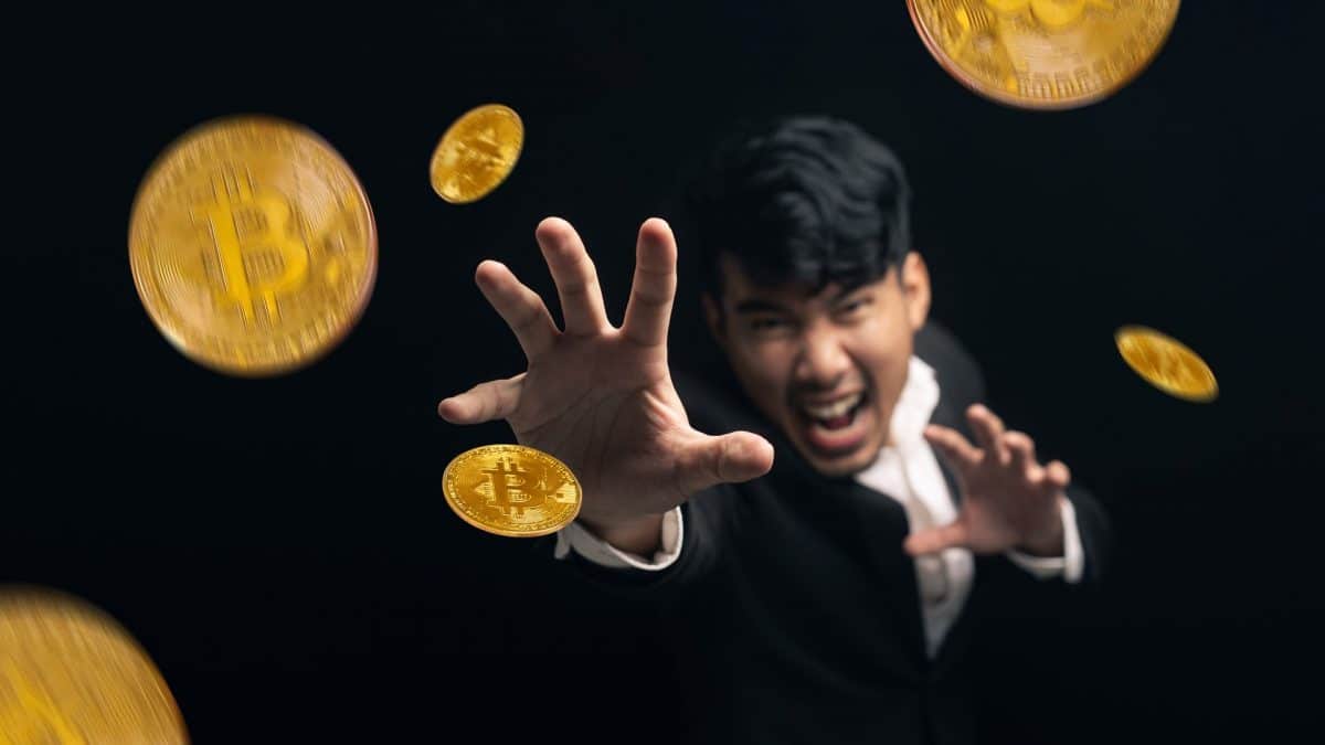 Investidor tentando agarrar suas criptomoedas.