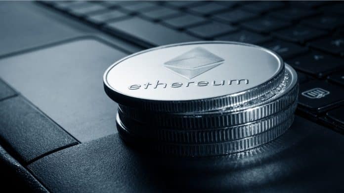 Pilha de moedas físicas de Ethereum sobre notebook.