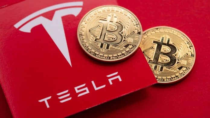 Logotipo da Tesla, empresa de Elon Musk, e moedas de Bitcoin.