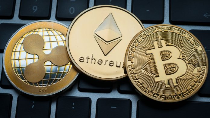 Criptomoedas Ripple, Ethereum e Bitcoin sobre teclado.