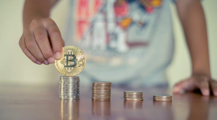 Criança empilhando moedas de bitcoin, criptomoedas e educação financeira para crianças e adolescentes