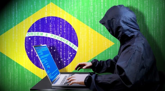 Hacker invadindo dispositivo próximo da bandeira do Brasil