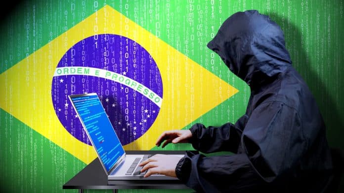 Hacker invadindo dispositivo próximo da bandeira do Brasil