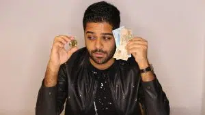 Homem olhando para Bitcoin enquanto segura notas de Real