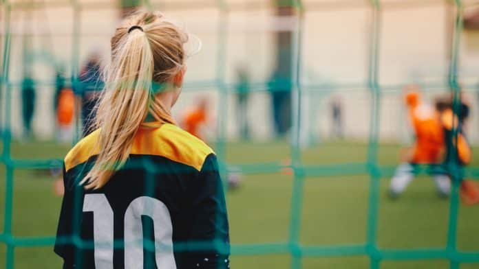 Jogadora de futebol feminino atenta aos lances