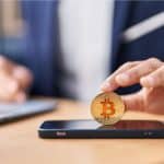 Jovem colocando bitcoin em celular