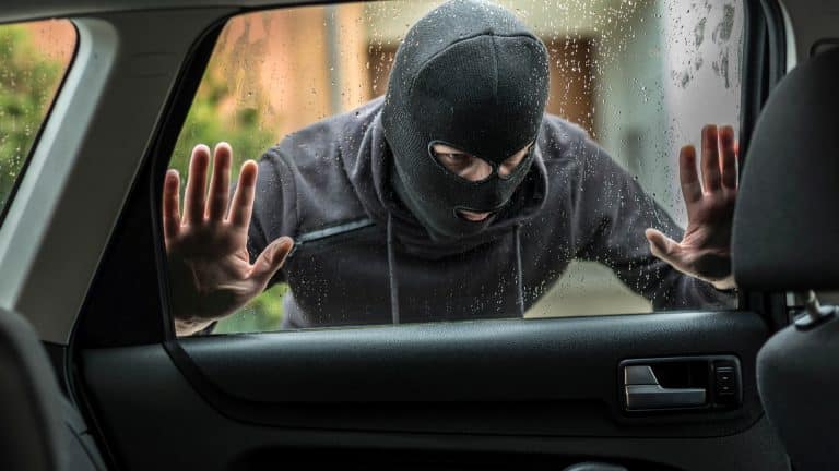Ladrão de carro olhando pela janela de veículo