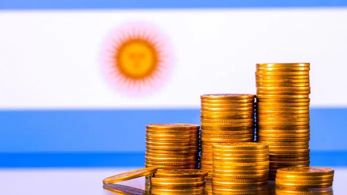 Monte de moedas próximo de bandeira da Argentina