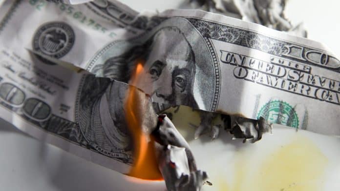 Nota de Dólar pegando fogo e rasgada