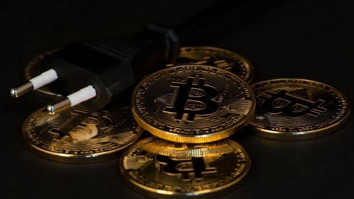 Moedas de Bitcoin e plug de tomada.