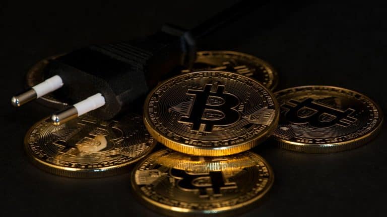Moedas de Bitcoin e plug de tomada.