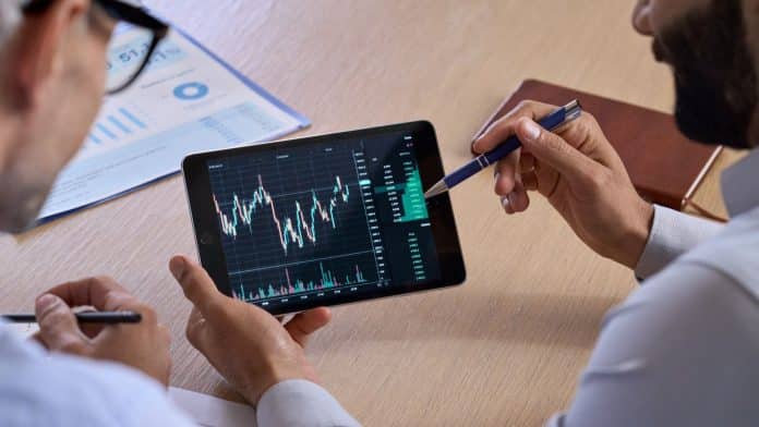 Investidores analisando preço do Bitcoin.