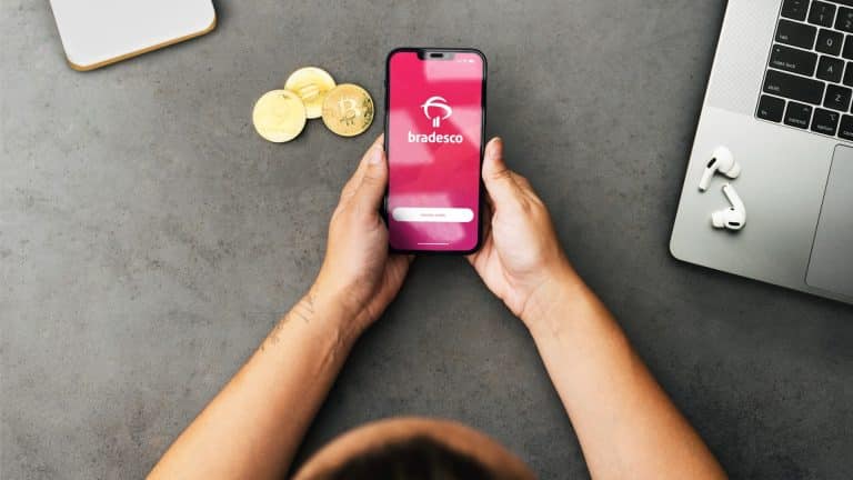 Aplicativo do Bradesco próximo de criptomoedas na mão de mulher