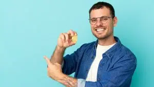 Brasileiro feliz segurando o bitcoin com confiança