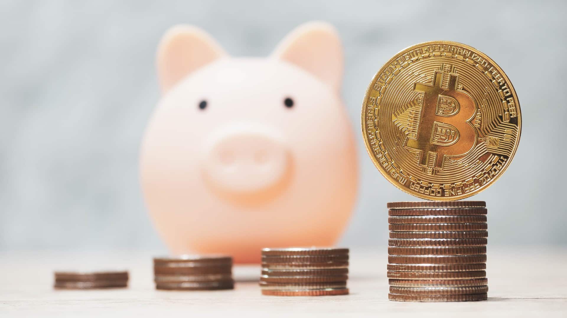 Cofrinho próximo de moedas de bitcoin físicas