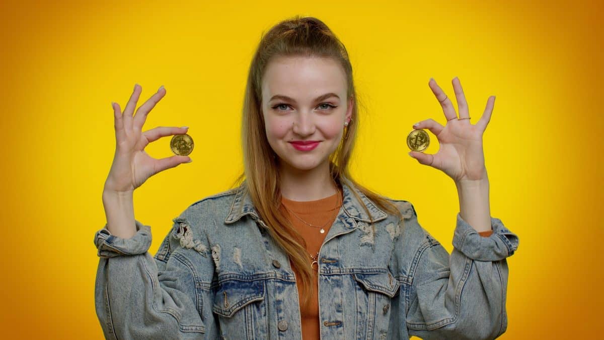 Mulher e Estudante segurando bitcoin e feliz