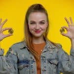 Mulher e Estudante segurando bitcoin e feliz