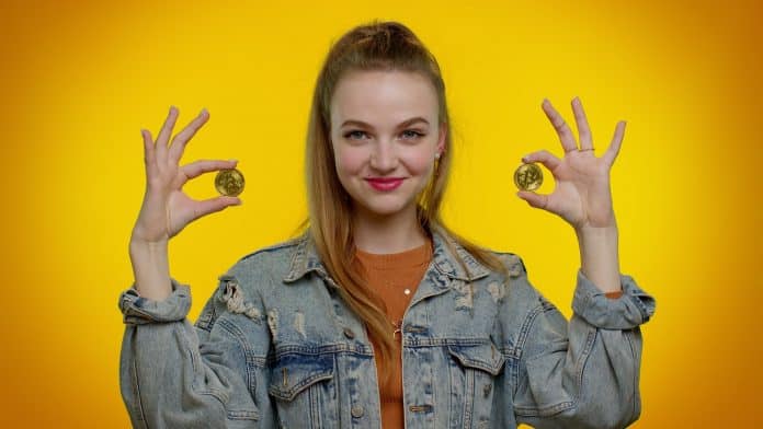 Mulher e Estudante segurando bitcoin e feliz