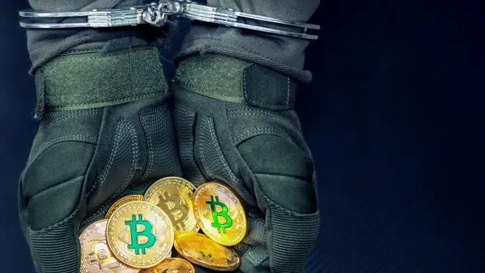 Homem preso segurando bitcoin verde e amarelo