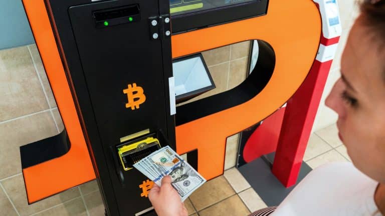 Mulher acessando caixa eletrônico de bitcoin