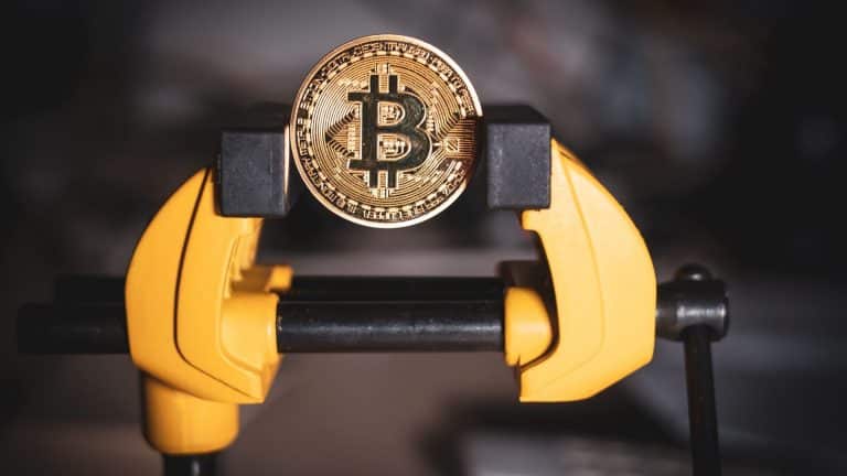 Moeda de Bitcoin sendo pressionada em torno.
