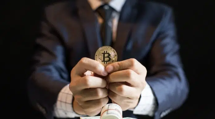 Executivo segurando moeda de Bitcoin.