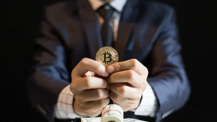 Executivo segurando moeda de Bitcoin.