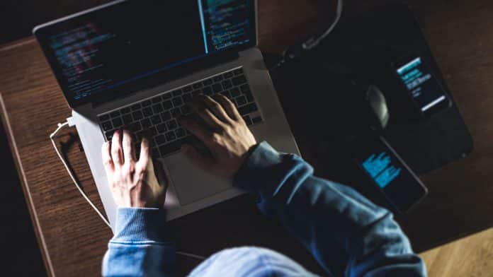 Hacker trabalhando em seu notebook.