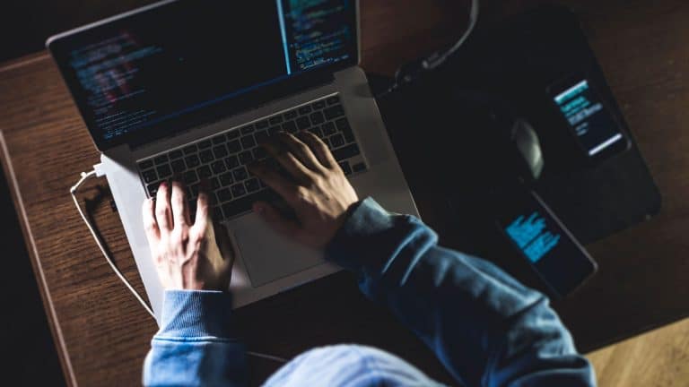 Hacker trabalhando em seu notebook.