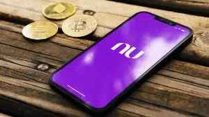 Aplicativo do Nubank e moedas de Bitcoin.