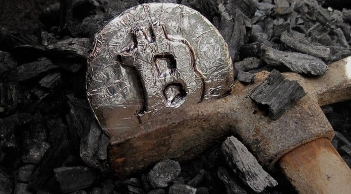 Picareta de mineração enferrujada e moeda de Bitcoin.