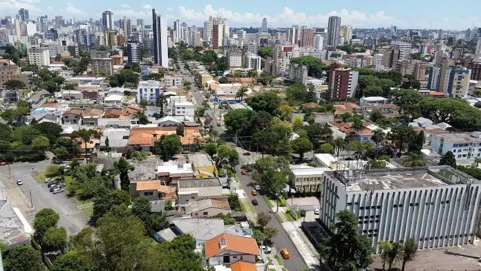 Centro de Curitiba em destaque, plano com criptomoedas