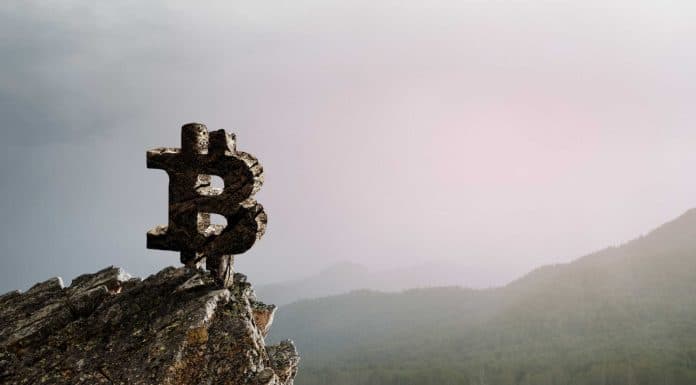 Símbolo do Bitcoin em topo de montanha.