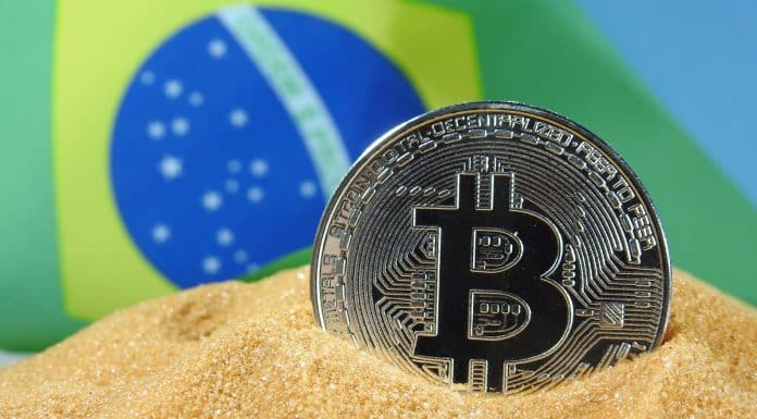 Bitcoin em monte de areia com bandeira do Brasil ao fundo Ewan Kennedy