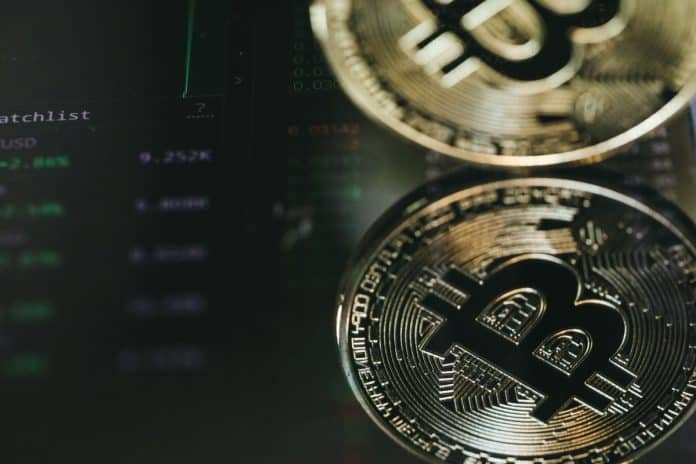 Imagem de bitcoin espelhado em tela de negociações