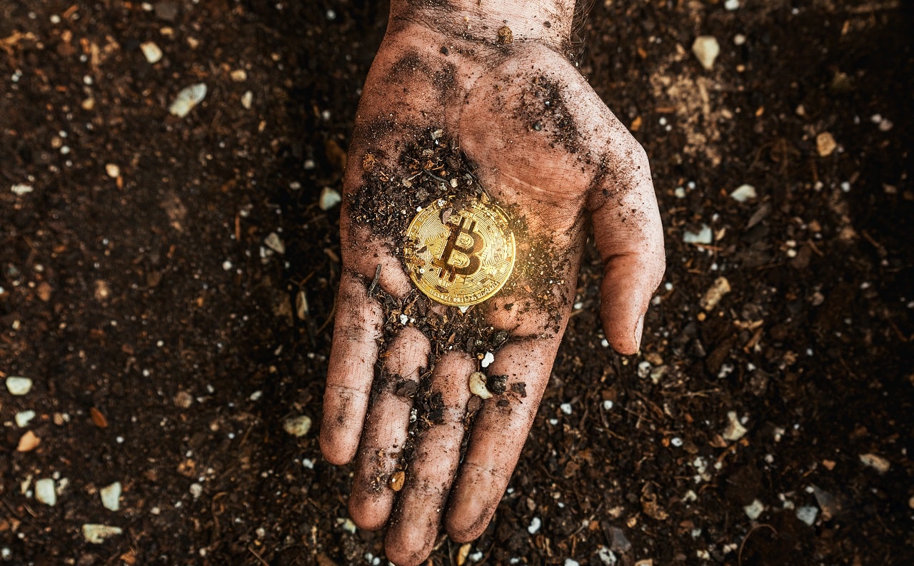 Mão segurando bitcoin - minerador
